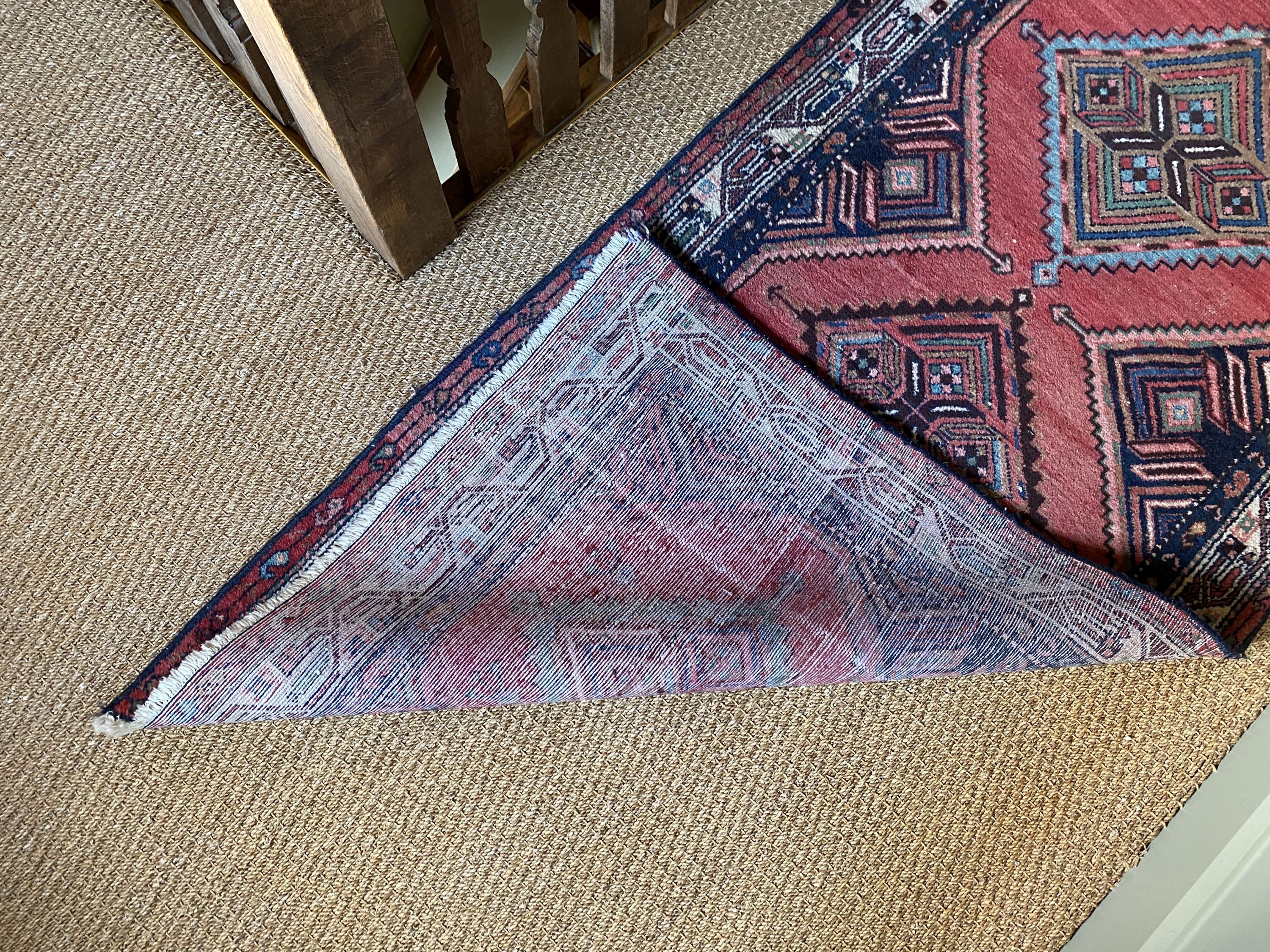 A Persian red ground runner, with five central lozenges, multi-bordered, 303 x 98cm